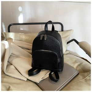 Close-up of black pebble leather backpack with silver zippers and top handle