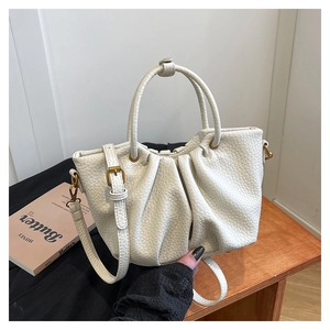 Gros plan détaillé du sac en cuir plissé blanc avec texture litchi et boucle dorée