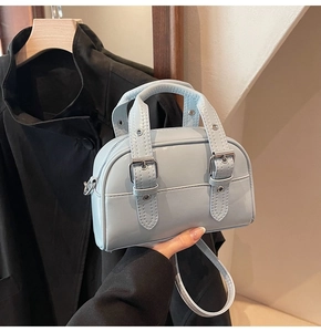 Détail d'un mini sac Boston bleu clair avec boucles rétro et finitions argentées