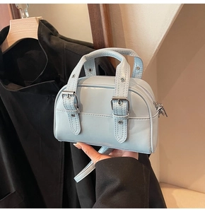 Détail du mini sac à main bleu glacier avec finition brillante et boucles en métal argenté