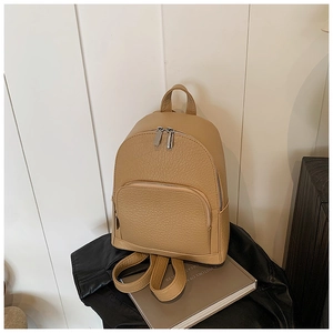 Side view of camel litchi grain leather backpack showing texture and dual metal zippers