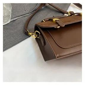 Detail of vintage brown crossbody bag with smooth leather and suede texture contrast