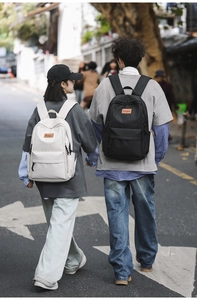 Detailed outdoor shot of minimalist laptop backpacks in black and beige finishes