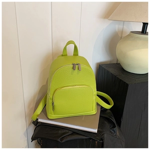 Close-up of lime green lychee grain leather mini backpack with silver metal zippers