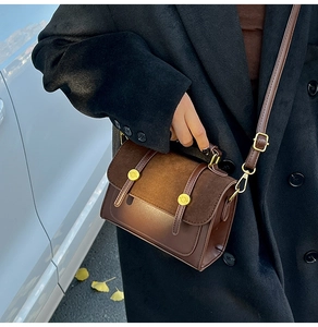 Detail of vintage brown leather crossbody bag with metal rivets and suede patchwork