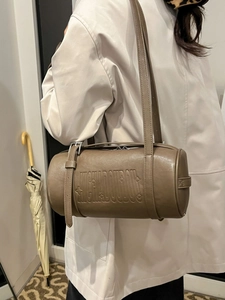 Vintage cylinder underarm bag in brown faux leather with embossed lettering and metal buckles