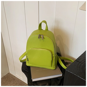 Close-up of green pebble leather mini backpack with dual zippers and adjustable straps