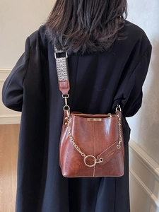 Sac seau vintage marron avec bandoulière jacquard et chaîne dorée sur mannequin