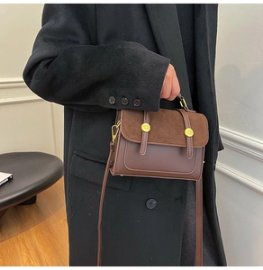 Chic retro brown satchel detail showing contrast leather textures and gold hardware