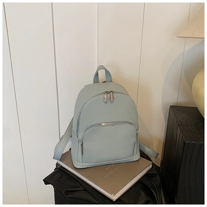 Close-up of litchi textured leather backpack with silver metal zippers in mint green color