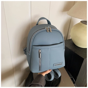 Detail of light blue lychee pattern leather backpack with silver zippers and metal logo
