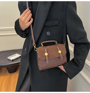 Detail of vintage brown crossbody bag with suede patchwork and gold metal buckle