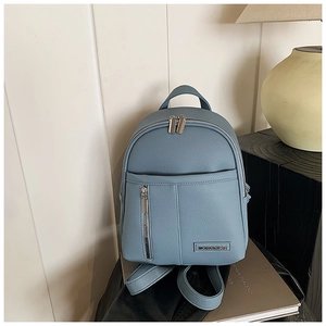 Close-up of light blue lychee pattern leather backpack with metallic brand plate