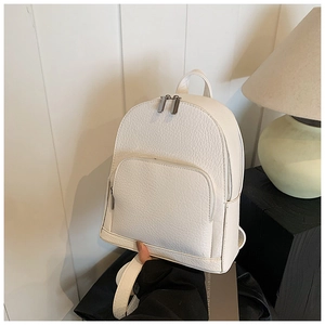 Close-up of white lychee grain leather backpack with silver zippers and front pocket