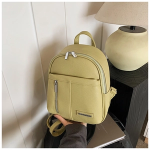 Close-up of lime green pebbled leather mini backpack with silver metal zippers