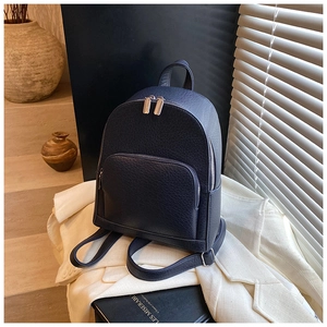 Detail of navy blue lychee texture leather backpack with silver zippers and front pocket
