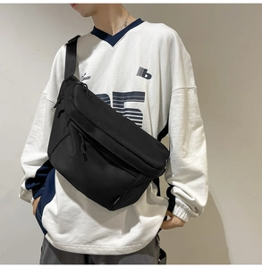 Men wearing black minimalist nylon crossbody bag with large capacity over white sweatshirt