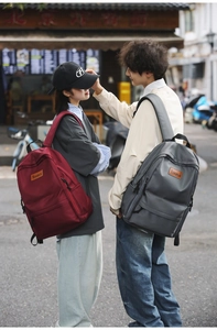 Outdoor lifestyle shot showing burgundy and dark grey minimalist student backpacks