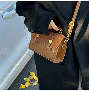 Detailed side view of vintage brown patchwork crossbody bag with gold metal buckle