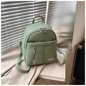 Detail of light green pebble leather mini backpack with metal logo and adjustable straps