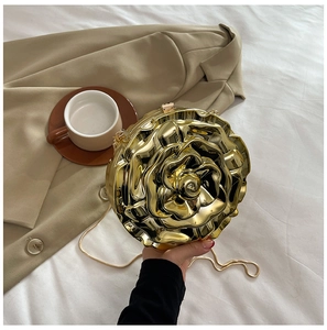 Detailed close-up of golden rose-shaped evening bag with metallic petals and chain