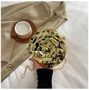 Close-up of golden rose shaped evening clutch bag with intricate 3D layered metal petals