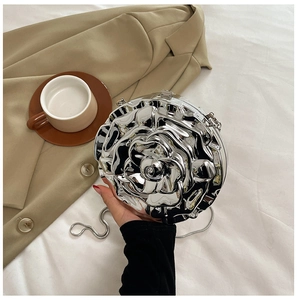 Macro detail of silver rose-shaped chain bag with 3D metallic flower petal design