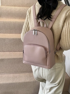 Minimalist dusty rose lychee grain faux leather backpack with silver zippers on steps