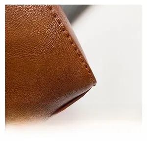 Close-up of brown lychee-patterned leather with precision stitching on a Boston bag