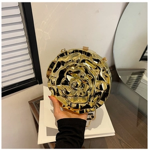 Detail of a 3D gold rose clutch with metallic petals and a secure metal clasp