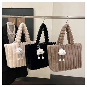 Detail of plush tote bags with bubble handles and cloud charms in three colors