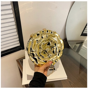 Detailed view of a golden 3D rose-shaped clutch bag with metal chain and petal texture