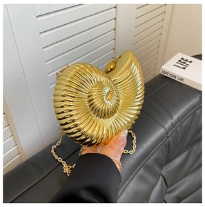 Detailed close-up of golden snail-shaped evening bag with metallic chain and texture