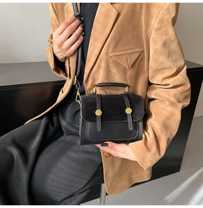 Detail of vintage crossbody bag showing faux suede flap and gold buckle hardware