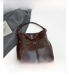 Détail du sac hobo marron café avec rivets argentés et finition vernie brillante