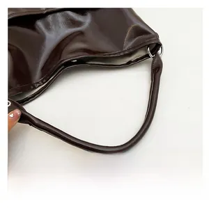 Détail de la poignée en cuir poli marron foncé avec fermeture magnétique en métal