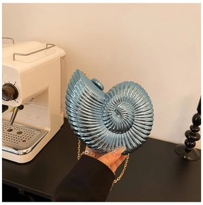 Detailed shot of metallic blue snail shell evening clutch bag with golden chain strap