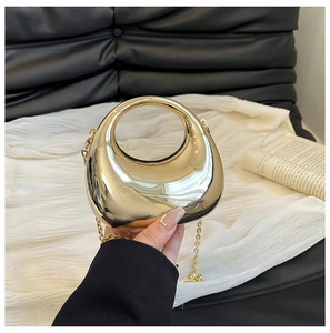 Bolso de mano de acrílico dorado brillante con asa integrada y cadena de metal fina
