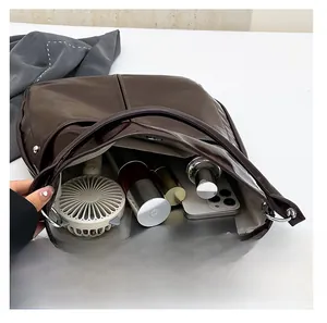 Détail de l'intérieur spacieux du sac cabas marron avec texture en similicuir brillant