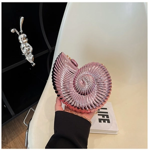 Detail of rose pink metallic snail clutch bag with ribbed texture and gold chain strap