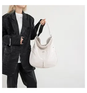 Détail du sac cabas en cuir verni blanc crème avec clous argentés et longues anses