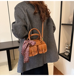 Brown glossy bowling bag with decorative polka dot scarf shown on a model's shoulder