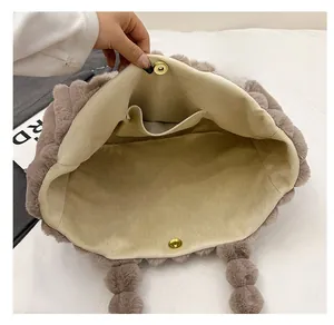 Detail shot of the plush tote bag interior with beige lining and gold magnetic closure