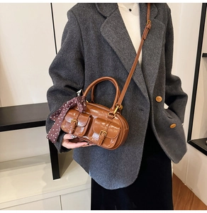 Detail of vintage brown Boston bag with front pockets and elegant polka dot scarf