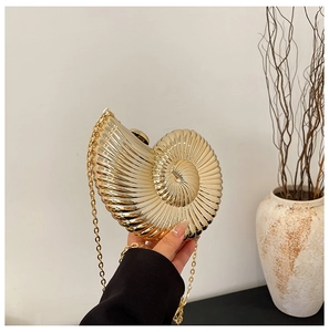 Detailed view of snail shell shaped acrylic evening clutch with gold metal chain