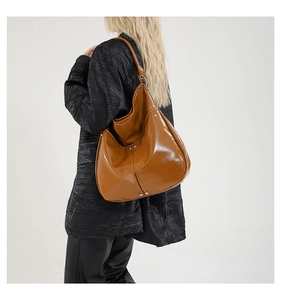 Détail du sac hobo caramel montrant la texture brillante et l'anneau métallique argent