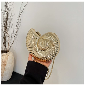 Detailed view of snail shell shaped acrylic evening bag with gold metallic spiral texture