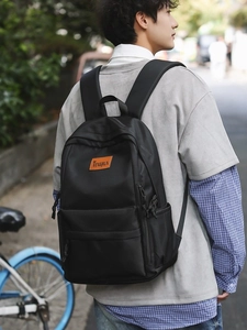 Minimalist black backpack for women showing the high capacity main bag and side pockets
