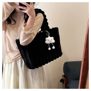 Detail of black faux fur tote bag with vertical quilting and a white cloud charm