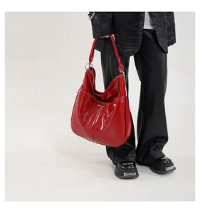 Détail du sac hobo rouge brillant avec anneau en argent et rivets décoratifs